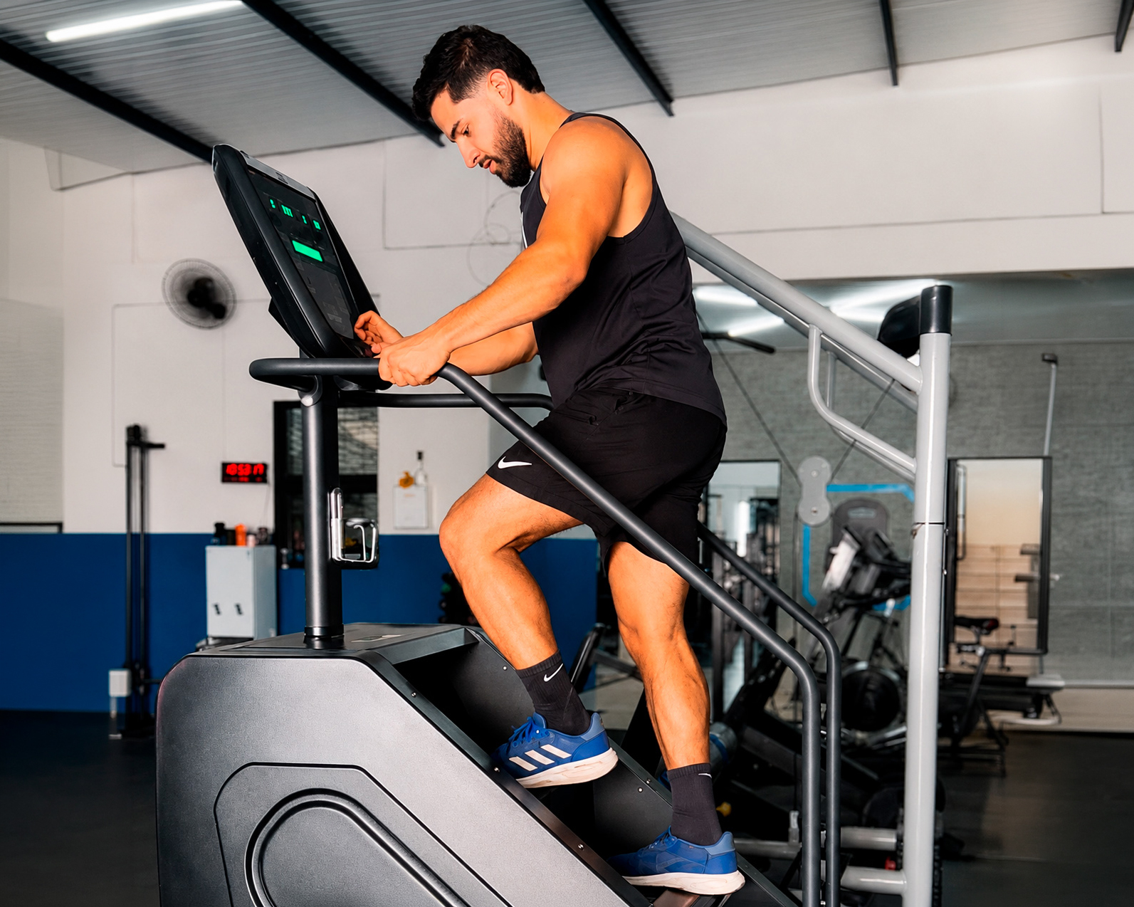 Aluno do Studio Personal Extreme em treino de cardio na escada ergométrica