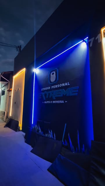 Fachada do Studio Personal Extreme à noite com iluminação em LED azul