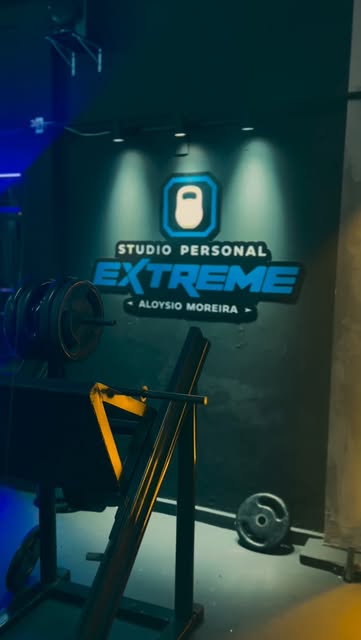 Interior do Studio Personal Extreme com letreiro retroiluminado e área de peso livre