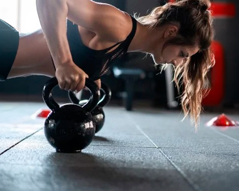 Aluna do Studio Personal Extreme em treino funcional com kettlebell